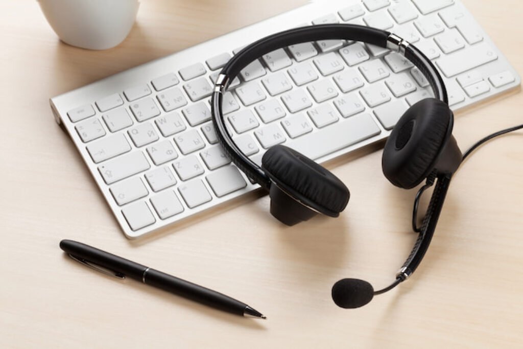 Headphone ao lado de um teclado de mac.
