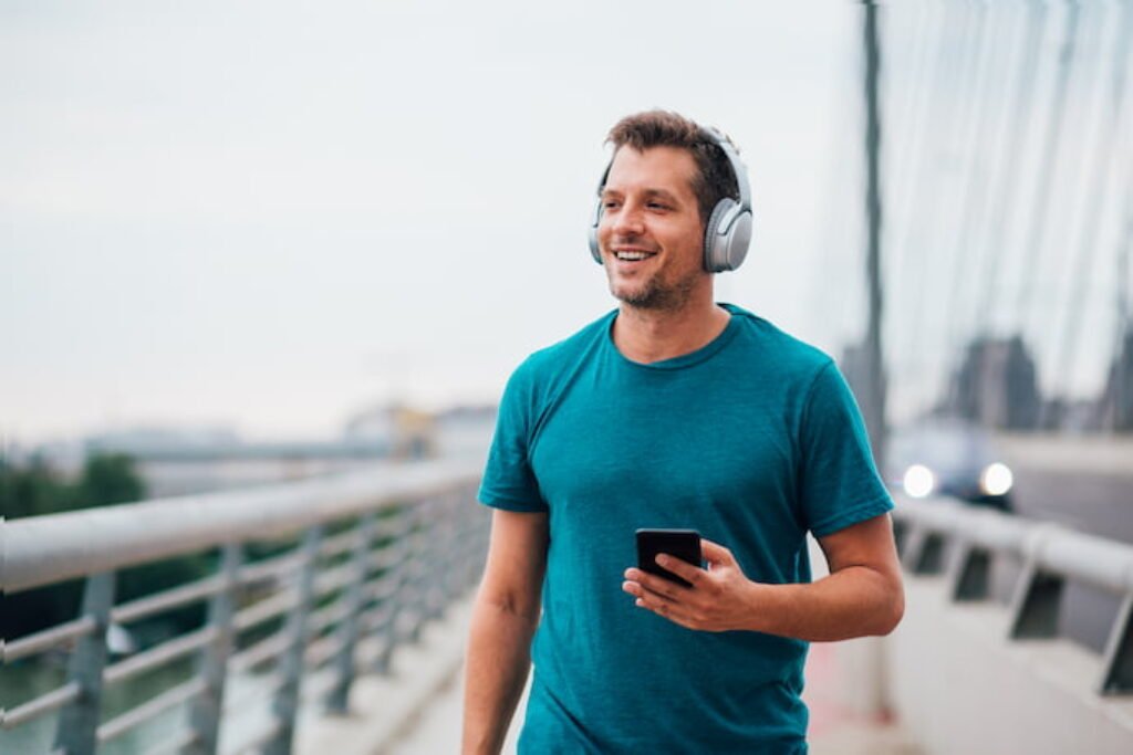 Homem andando na rua de fone em um dia nublado.