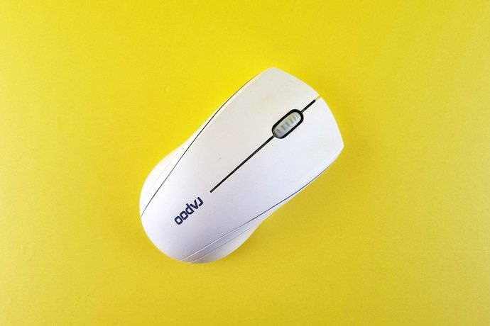Mouse branco em um fundo amarelo.