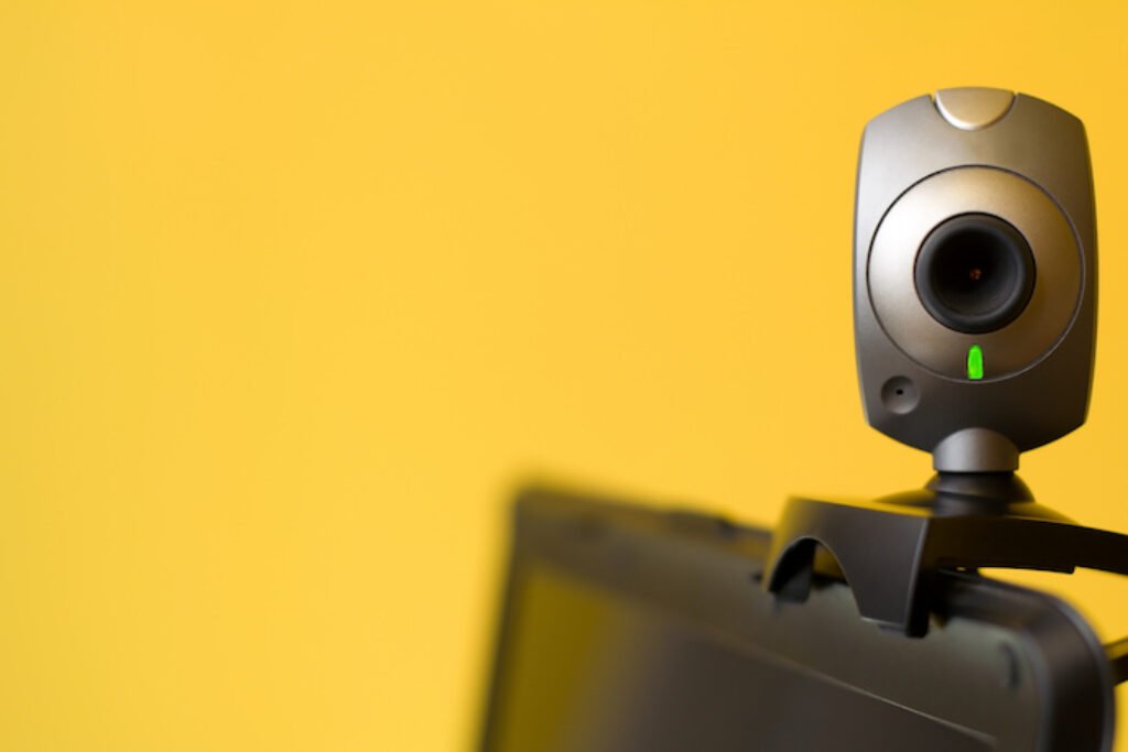 Webcam no monitor de um PC em um fundo amarelo.