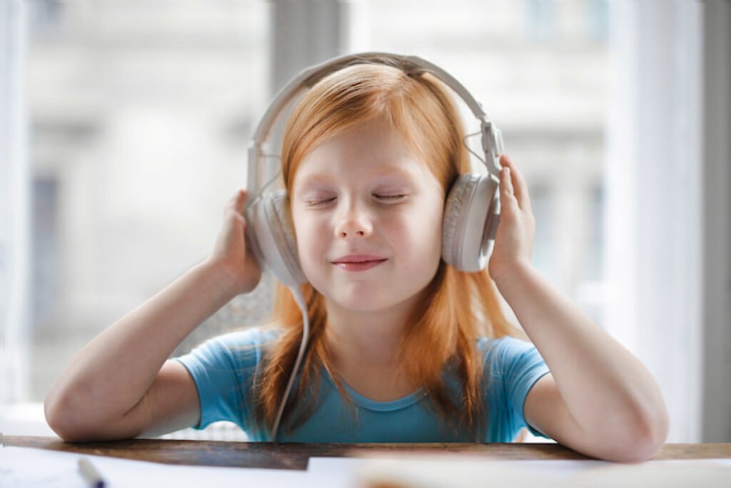 Menina escutando música em um fone de ouvido branco.