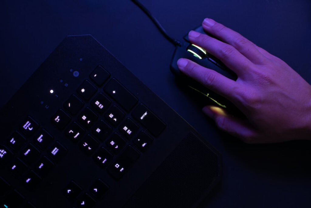 Pessoa usando mouse ao lado de um teclado.
