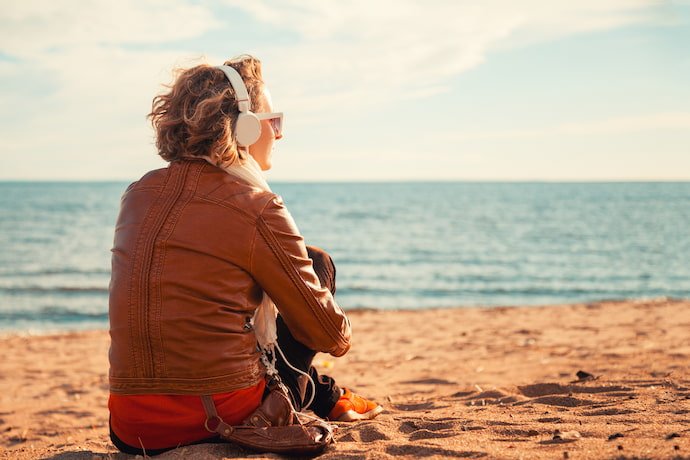 Homem de fone de ouvido na praia.
