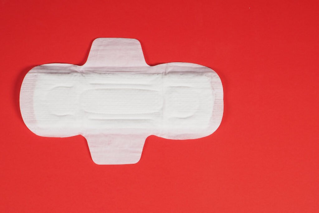 Absorvente aberto em um fundo vermelho.