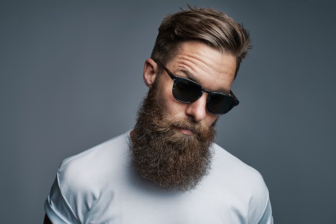 Homem barbudo de óculos olhando para a foto.