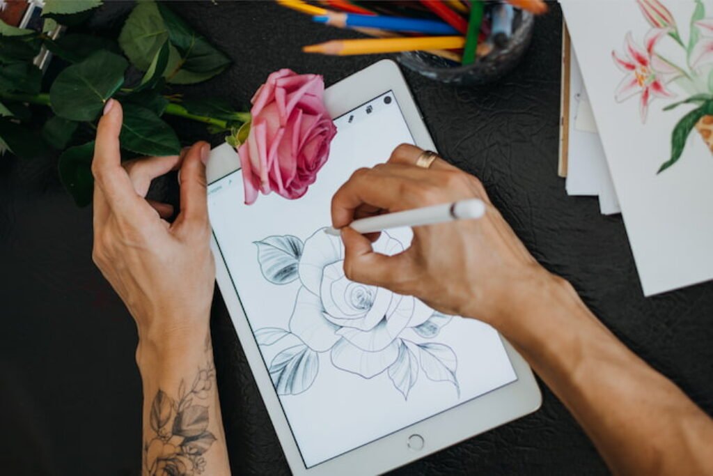 Pessoa desenhando uma rosa em um tablet.
